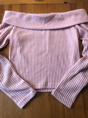 Rosa ribbad offshoulder topp - Säljer en söt rosa ribbad offshoulder topp med långa ärmar. Stickad och mjukt matrial väldigt fint skick. Skicka pm vid intresse 
