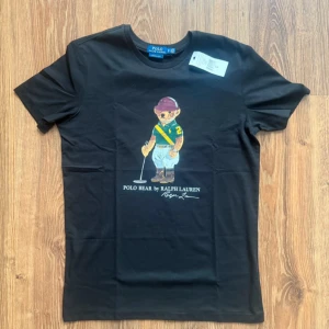 Svart Polo Bear t-shirt från Ralph Lauren - Svart t-shirt från Polo Ralph Lauren med ikoniskt Polo Bear tryck.  Storlek M, Helt ny!