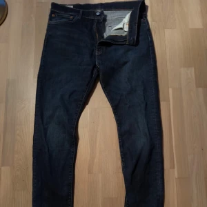 Levi's 512 slim jeans  - Mörkblå jeans från Levi's med klassisk femficksdesign och raka ben. Snygga kontrastsömmar och ikonisk läderpatch bak i midjan. Jeansen är sparsamt andvända dock finns lite små slitningar, nypris ca 1350. Dem är 36 i midja men skylla säga att dem även passar 34 som jag har på resten av mina jeans, för referens så är jag 190, 95kg. Tveka inte på att höra av dig vid minsta lilla, öppen för bud 🤩