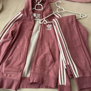 Rosa dress från Adidas med huva - Säljer en snygg dress från Adidas i dammigt rosa med vita ränder 