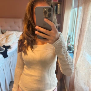 Ribbad ljusbeige långärmad tröja - Säljer en ribbad långärmad tröja i ljusbeige med fyrkantig ringning. Tröjan är figurnära och har en clean, stilren look som passar perfekt till jeans eller kjol. Materialet är stretchigt och mjukt, vilket gör den superbekväm att bära.