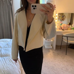 Beige croppad kavaj med bred krage - Snygg beige croppad kavaj köpt från Gina Tricot. Använd endast en gång. 