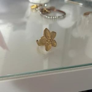 trendig blom-guldring🤩 - säljer denna sjukt fina ringen i guld. säljer denna då jag har två likadana och endast använder en❤️den är i rostfritt stål och har inga defekter då den aldrig blivit använd! 