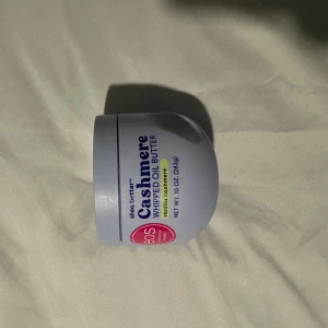 EOS Cashmere Whipped Oil Butter - SISTA DIREKT FRÅN USA EOS Cashmere Whipped Oil Butter med doft av vanilj cashmere. Kommer i en ljuslila rund plastburk på 283g. Perfekt för att återfukta huden med en lyxig känsla och mjuk finish. Innehåller sheasmör och oljor för extra näring.