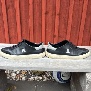 Svarta sneakers från Axel Arigato - Säljer dessa stiliga sneakers från Arigato. Använda en del men fortfarande i okej skick. Storlek 46 men passar även 45. Köpta för 2200 och säljer för 700kr