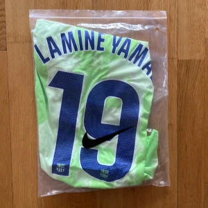 Barça Lamine Yamal fotbollströja S - Barcelona fotbollströja med Lamine Yamal och nummer 19 på ryggen. Tröjan är ljusgrön med mönster, har korta ärmar och är tillverkad i Dri-Fit material. Nike-logga, Spotify sponsor och FCB klubbmärke på bröstet. Perfekt för dig som älskar Barça och vill ha en unik matchtröja.