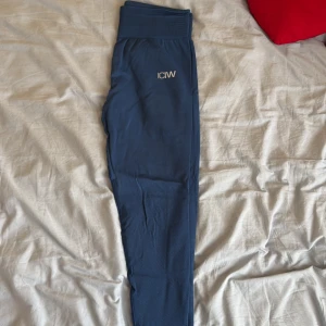 Blå seamless tights från ICANIWILL - Snygga blå tights från ICANIWILL med hög midja och seamless design. Perfekta för träning eller chill, med diskret logga på höften och stretchigt material som sitter tajt. Tightsen har en bred resår i midjan för extra support.