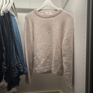 Ljusbeige stickad tröja Gina Tricot XS - Mysig ljusbeige stickad tröja från Gina Tricot i ullblandning. Tröjan har rund halsringning, ribbade muddar och en klassisk, enkel design som är lätt att matcha. Perfekt för lager-på-lager under kyliga dagar.