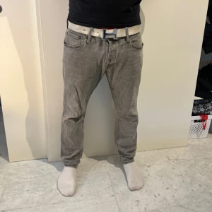 Grå tapered jeans Jack & Jones 32/32 - Snygga grå jeans från Jack & Jones i modellen Tapered Mike. Jeansen har en avsmalnande passform, klassiska fem fickor och är tillverkade i mjukt denimtyg. Perfekta för dig som gillar en avslappnad men ändå stilren look.