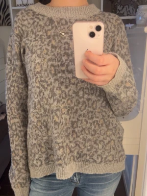 Grå leopardmönstrad stickad tröja - Mysig stickad tröja i grått med leopardmönster och inslag av beige.