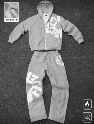 Grå fleecefodrad hoodie - Snygg grå hoodie med huva och dragkedja framtill. Dressen har stora vita tryck i ett vågigt mönster över bröstet och axeln. Tillverkad i mjukt fleecematerial som håller dig varm. Perfekt för dig som gillar streetwear och vill sticka ut.