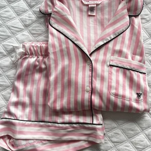 Victoria Secret Pyjamas - Säljer min Victoria Secret Pyjamas i storlek XS. Köptes på Victoria Secret butiken i London i december 2024. Tyvärr lite för liten för mig, därav har den även spräckts i sömmen. Ingenting som syns eller är märkbart på då det är precis i nacken, och täcks utav nackkragen på baksidan (Se sista bilden) Köpte den för 1200kr 🩷