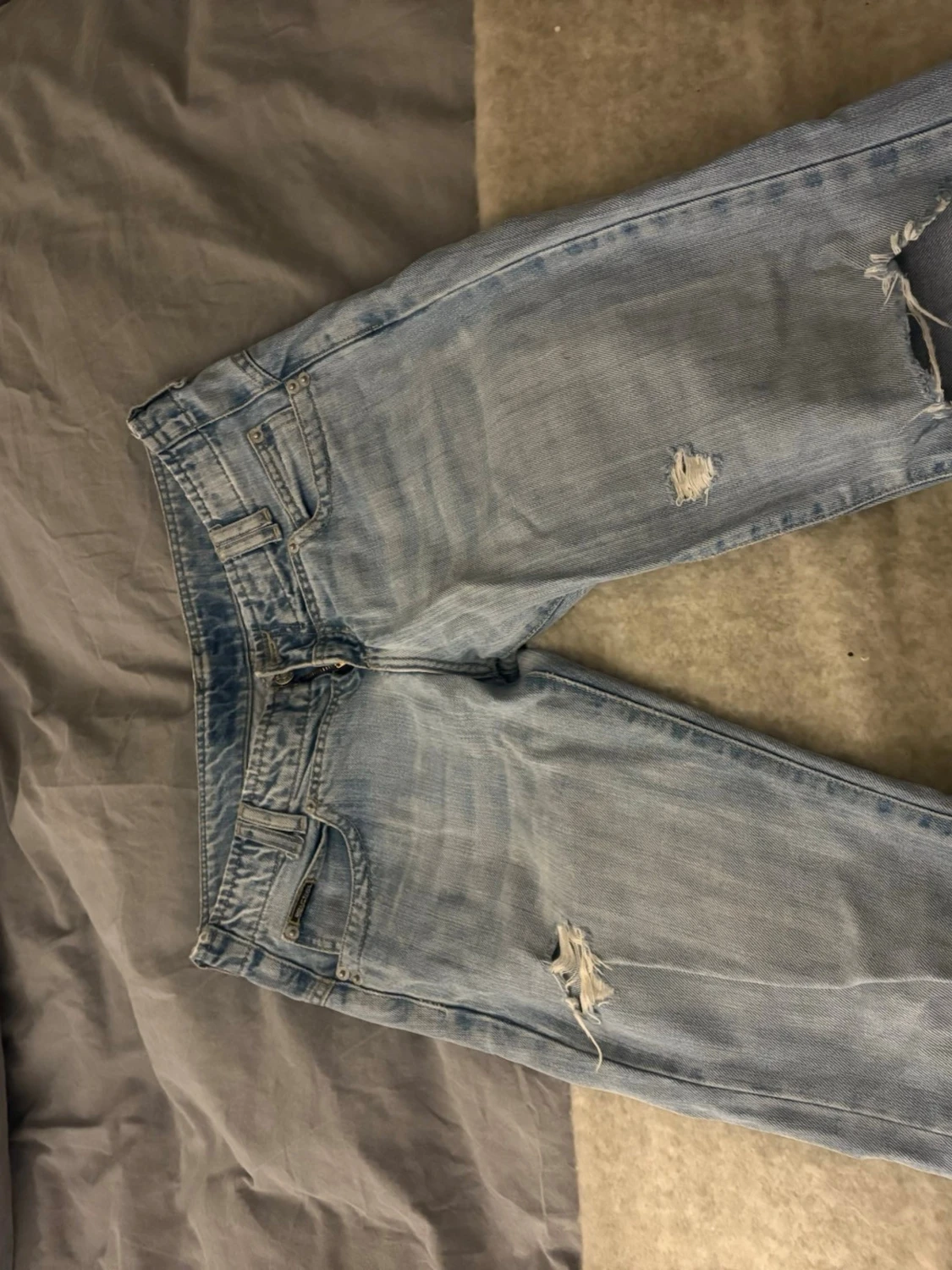 Ljusblå slitna jeans med broderade fickor