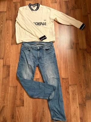 Blå jeans från Dressmann Regular Fit - Säljer ett par klassiska blå jeans från Dressmann i modellen Regular Fit. Jeansen har fem fickor, raka ben och snyggt slitna detaljer framtill. Passar dig som gillar en tidlös look och vill ha ett par bekväma jeans till vardags. Storlek 34/30 men sitter som 31/32. Skriv om funderingar 😇🙌