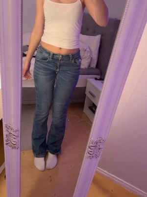 Blå bootcut jeans från Gina Tricot - Säljer ett par blå bootcut jeans från Gina Tricot i storlek 170. Bakfickan är sydd för den har gått sönder en gång men borde kunna användas!❣️
