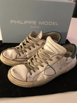 Philippe Model prsx  - Säljer ett par vita Philippe Model prsx med gröna detaljer. 🙌nypris 320€🙌 Skorna har används flitigt men har blivit väl omhändertagna. Innersulan är lite sönder och längst bak på sulan har det slitigts igenom på båda skorna. Men annars är dem i relativt bra skick