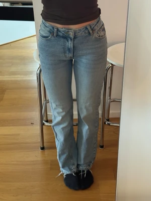 Ljusblå raka jeans - Mid wide jeans i storlek 24/30, vilket är xs. Jeansen är mid waist och har en rak passform på kroppen. Jeansen är superfint formade efter kroppen. Sitter åt i midjan och lösa runt benen och är stretchiga, precis så som man vill ha. Säljer pga platsbrist. Använda företaget gånger då de är väldigt fina jeans som jag trivts bra i!  Obs, sömmen längst ned vid fötterna är uppsprättade för att få en längre benlängd.  Köpta för 599 på bikbok, de är från märket never denim. Skickar samma dag som du köpe