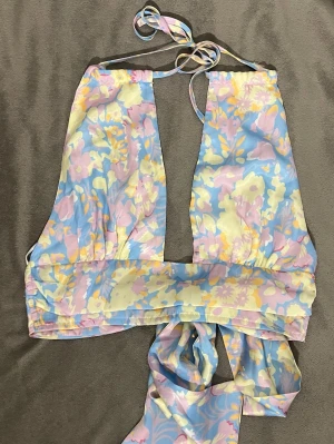 Blommig omlottopp från Double Crazy - Säljer en superfin omlottopp från Double Crazy i pastellfärgat blommönster med öppen rygg 