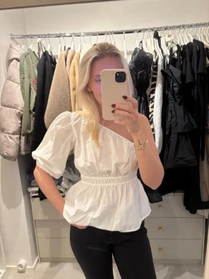 Vit oneshoulder topp med puffärm -  vit oneshoulder topp med en puffig kort ärm och resår i midjan