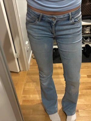 Bootcut jeans från ONLY ljusblå S - Säljer ett par ljusblå bootcut jeans från ONLY i storlek S/34. Jeansen har klassisk femficksdesign, normal passform och är tillverkade i mjukt denimtyg. Perfekta för dig som gillar en retroinspirerad look med utsvängda ben. Jättesköna, använda fåtal gånger!❤️