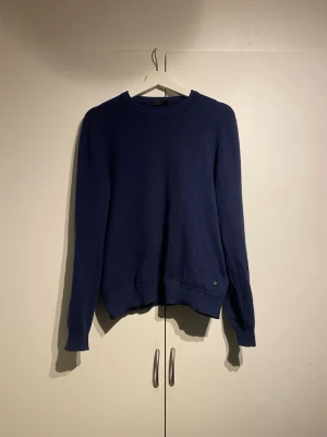 Zegna Merinoulls Tröja  - En stilren mörkblå stickad tröja från Zegna med rund halsringning och långa ärmar. Välanvänd men i okej skick. Tröjan har ribbade muddar vid ärmslut och nederkant samt en liten metallbricka nere vid fållen med ett Z. Nypris på denna är 8.000kr. Storlek M. Enormt kvalitativ och bekväm. 