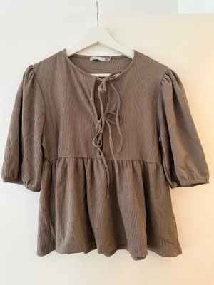 En ljus brun blus ifrån lager 157.  - Säljer en brun blus ifrån lager 157, storlek S. En fin blus till sommaren. 