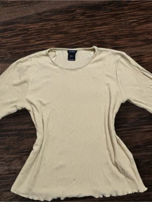 Beige ribbad topp från Lindex - Vi kan diskutera priset.En enkel och stilren beige ribbad topp från Lindex i storlek S. Toppen har lång ärm, rund halsringning och är tillverkad i ett mjukt stretchigt material. Perfekt att matcha med jeans eller kjol för en clean look.