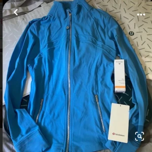 Blå träningsjacka från Lululemon - Snygg blå träningsjacka från Lululemon med silvrig dragdjedja, sååå fin färg och helt oanvänd🩵💙🩵💙🩵