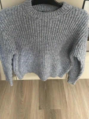 Ljusblå ribbad stickad tröja - Mysig ljusblå stickad tröja med ribbad struktur och rund hals. Perfekt för kyliga dagar och enkel att matcha med jeans eller kjol. Långärmad modell som ger en avslappnad och skön vibe.