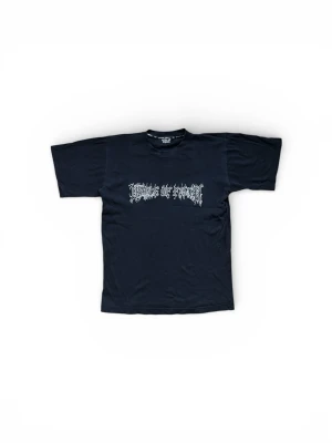 Vintage Svart Cradle of Filth t-shirt strl S - Svart vintage t-shirt med tryck av bandnamnet "Cradle of Filth" framtill.   Observera att det finns hål i sömmen under ena armhålan och vid halsringen.  Storleken säger XS men passar som S-M på mig.   Sitter snyggt och boxigt.