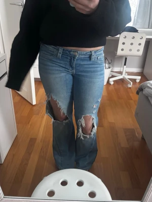 Lågmidjade bootcut jeans med revor - Lågmidjade bootcut jeans med stora hål. Sjukt coola!!🥰🥰💘💘 Storlek M och från Gina Tricot. I fint skick!!