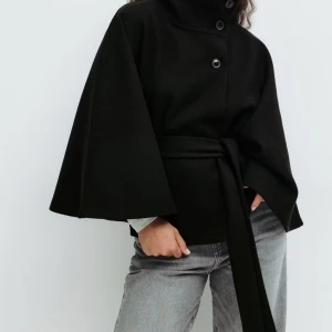 Belt cape jacket - Belt cape jacket från Gina Tricot i strl Xs/S, helt ny med prislapp. Svart poncho kappa
