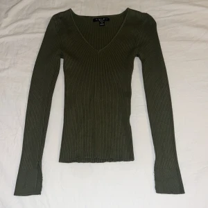 Olivgrön ribbad långärmad topp från New yorker  - Skön stretchig tröja som jag har klippt i armen för att få den så här öppen.