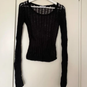 Svart stickad långärmad topp Weekday - Svart, stickad och ribbad långärmad topp från Weekday. Toppen har en tight passform och långa ärmar. Något nopprig från tvätt. Kan mötas upp på Södermalm!