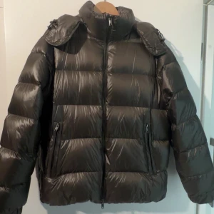 Olivgrön pufferjacka från Massimo Dutti L - Säljer en svart pufferjacka från Massimo Dutti i storlek L sitter som M. Jackan har en glansig finish, hög krage och dragkedja framtill. Två fickor med dragkedja och en klassisk pufferlook som håller dig varm under kalla dagar. Jacckan är hyfsat ny och har använt den totalt 2 gånger, inga skavanker på produkten. Nypris: 2000 mitt pris: 1200, kan går ner till 1000 vid snabbaffär.