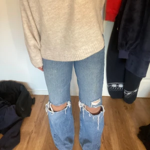 Blå ripped wide jeans från Gina Tricot - Säljer ett par ljusblå jeans från Gina Tricot med slitningar vid knäna. Hög midja . Inga defekter. 