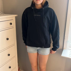 Svart hoodie med tryck och huva - Svart hoodie med snörning i huvan och texten 'MAKE ART NOT WAR' framtill. Stor peace-symbol i vitt på ryggen. Mjuk och skön modell med långa ärmar och ribbade muddar. Vet inte riktigt storlek men skulle gissa M!