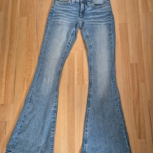 Bootcut jeans från Gina Tricot XS - Jättefina ljusblå jeans från Gina Tricot i storlek XS. Klassisk femficksmodell med snygga slitningar och dekorativa detaljer på bakfickorna. Jeansen har normal passform och är tillverkade i mjukt bomullsmaterial med lite stretch. 