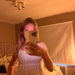 Vit topp blus med spetsdetalj - Supersöt vit topp blus med romantisk spetsdetalj i midjan och lätt puffade kortärmar. Blusen har en feminin, flowy passform och rundad urringning. Perfekt för dig som gillar en ljus och fräsch look!