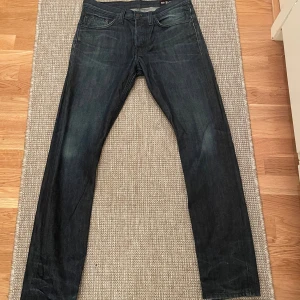 Crocker mörkblå jeans - Säljer ett par mörkblå Levi's 511 jeans med klassisk femficksdesign och raka ben. Jeansen har en snygg tvätt och är tillverkade i slitstarkt denim. Perfekta för dig som gillar en smalare passform och tidlös stil.