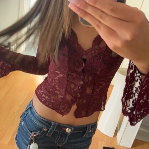 Vinröd spetsblus med v-ringning - Säljer en vinröd, långärmad spetsblus från Gina Tricot. 