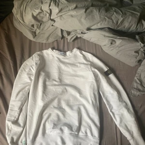 Stone Island sweatshirt 14/170 - Vit some Island tröja som är nästan helt felfri. Det finns minimala tecken på användning, saker som ingen märker. Det finns ingen qr kod på den eftersom att det är en äldre modell. Jag är 175 och den sitter perfekt 👌🏼 men om man villl att den ska sitta tight så funkar den för längre också. Skulle även passa nån som är 170.