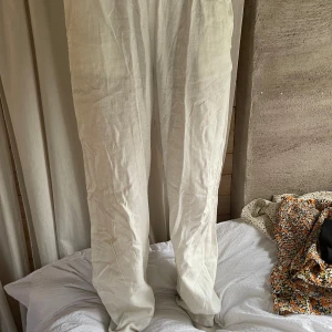 Vita linnebyxor från Lindex, stl 164 - Snygga och luftiga vita linnebyxor från Lindex i storlek 164. Byxorna har resår i midjan för extra komfort och är tillverkade i ett lätt och svalt linnematerial. Perfekta för varma dagar när du vill ha en chill och avslappnad look.