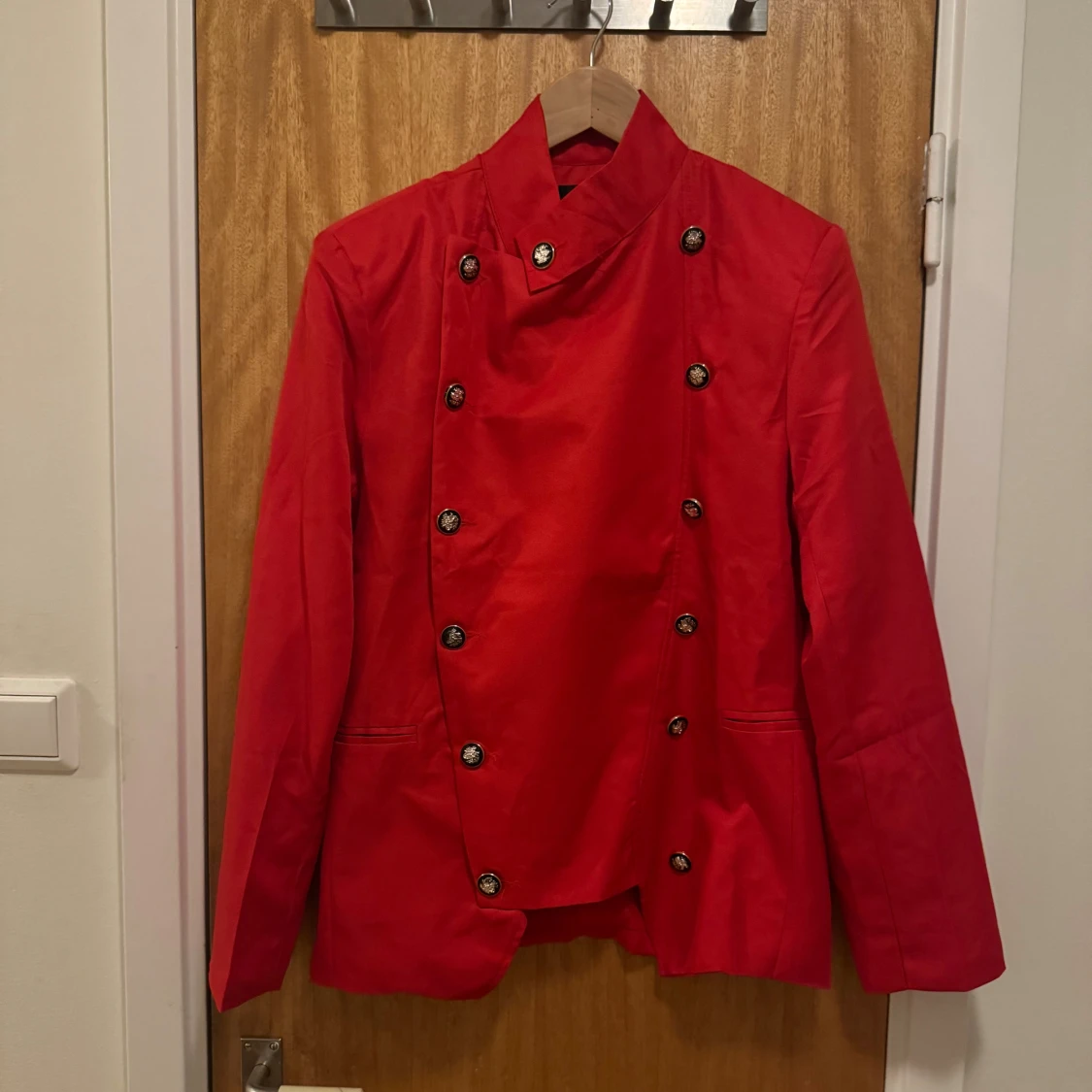 Röd skepparkavaj med dekorativa knappar