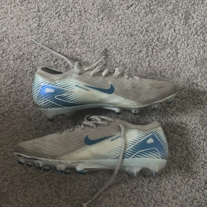Fotbollsskor - Hej, Jag säljer dem här NIKE AIR ZOOM MERCURIAL VAPOR 16 ELITE AG-PRO MAD AMBITION - BLÅ/BLÅ. Jag säljer pågrund av att de är för små. (Inte speciellt tvättade) Skriv till mig för frågor. Priset kan också diskuteras.