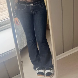 low waist Mörkblå bootcut jeans   med vita kontrastsömmar.  - Snygga mörkblå jeans från Gina Tricot med bootcut passform och vita kontrastsömmar. l med låg midja och dragkedja. är 40 men passar väl bra för 38 