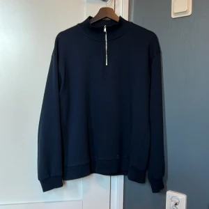 Ryvls 1/4zip - En jättefin 1/4zip från Ryvls i storlek 170/176 men passar större. Marinblå färg med en liten fläck längst ned som bör gå bort i tvätten. 