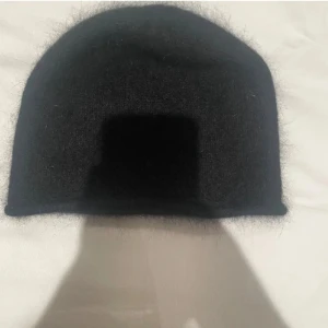 Svart fluffig mössa från FWSS - En svart, enkel och fluffig mjuk mössa  från FWSS. Perfekt för kalla dagar när du vill hålla dig varm och samtidigt se chill ut. Mössan har en klassisk rundad form och passar till de flesta stilar🌸