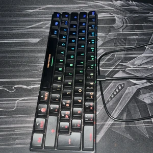 Deltaco Gaming Mini RGB Mekaniskt Tangentbord - Kompakt mekaniskt tangentbord med RGB-belysning och nordisk layout. Perfekt för gaming och skrivbord med begränsat utrymme. USB-anslutning, tydliga och färgglada tangenter. Tangentbordet är i gott skick, inga synliga defekter eller större slitage.
