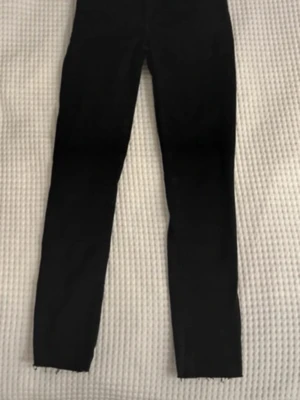 Svarta raka jeans från bikbok  - Snygga svarta jeans med rak passform och klassisk femficksdesign. Jeansen har en enkel look som passar till det mesta och är tillverkade i ett mjukt jeansmaterial. Perfekta för dig som gillar stilrena och tidlösa plagg.